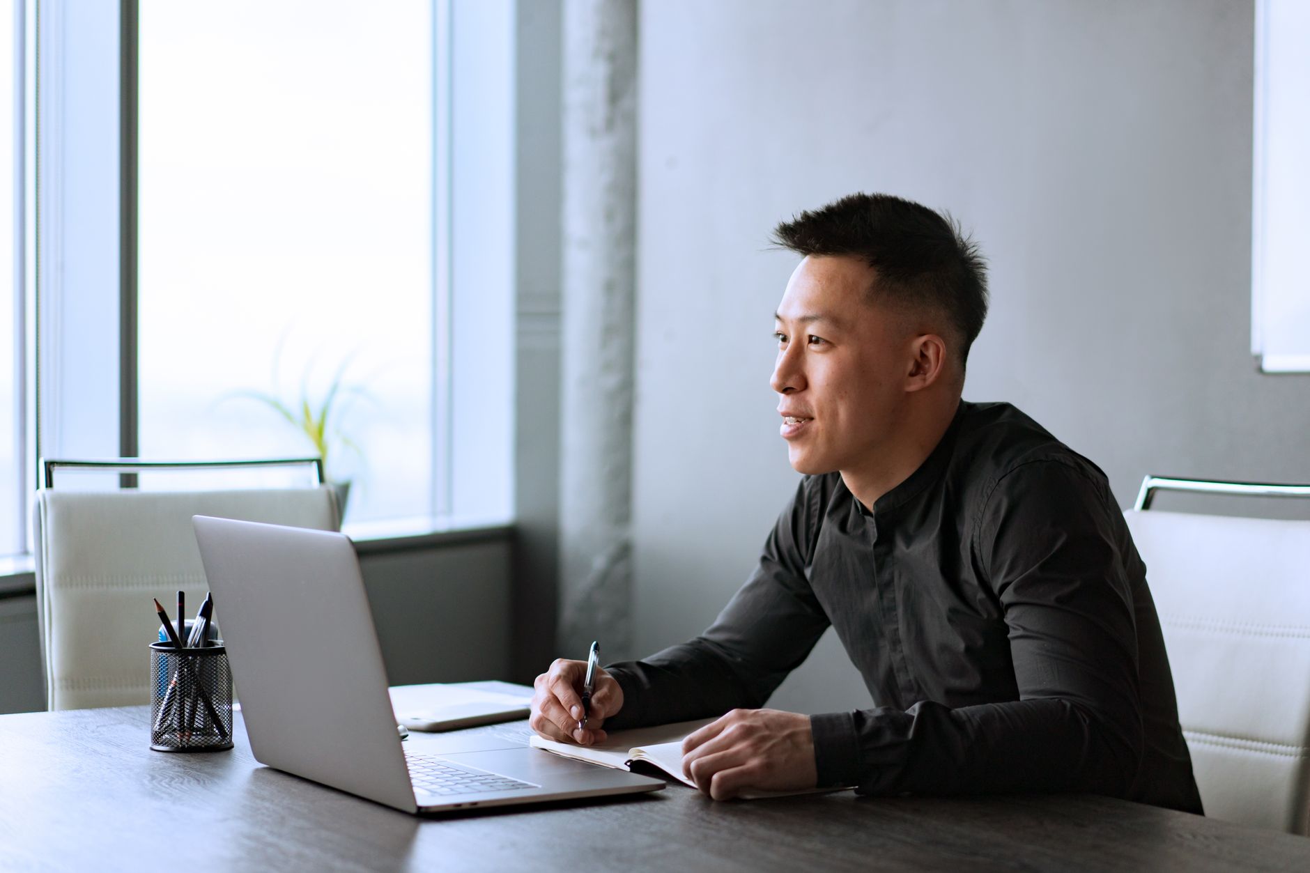 A job seeker reviewing a resume on a laptop next to a printed copy at a desk