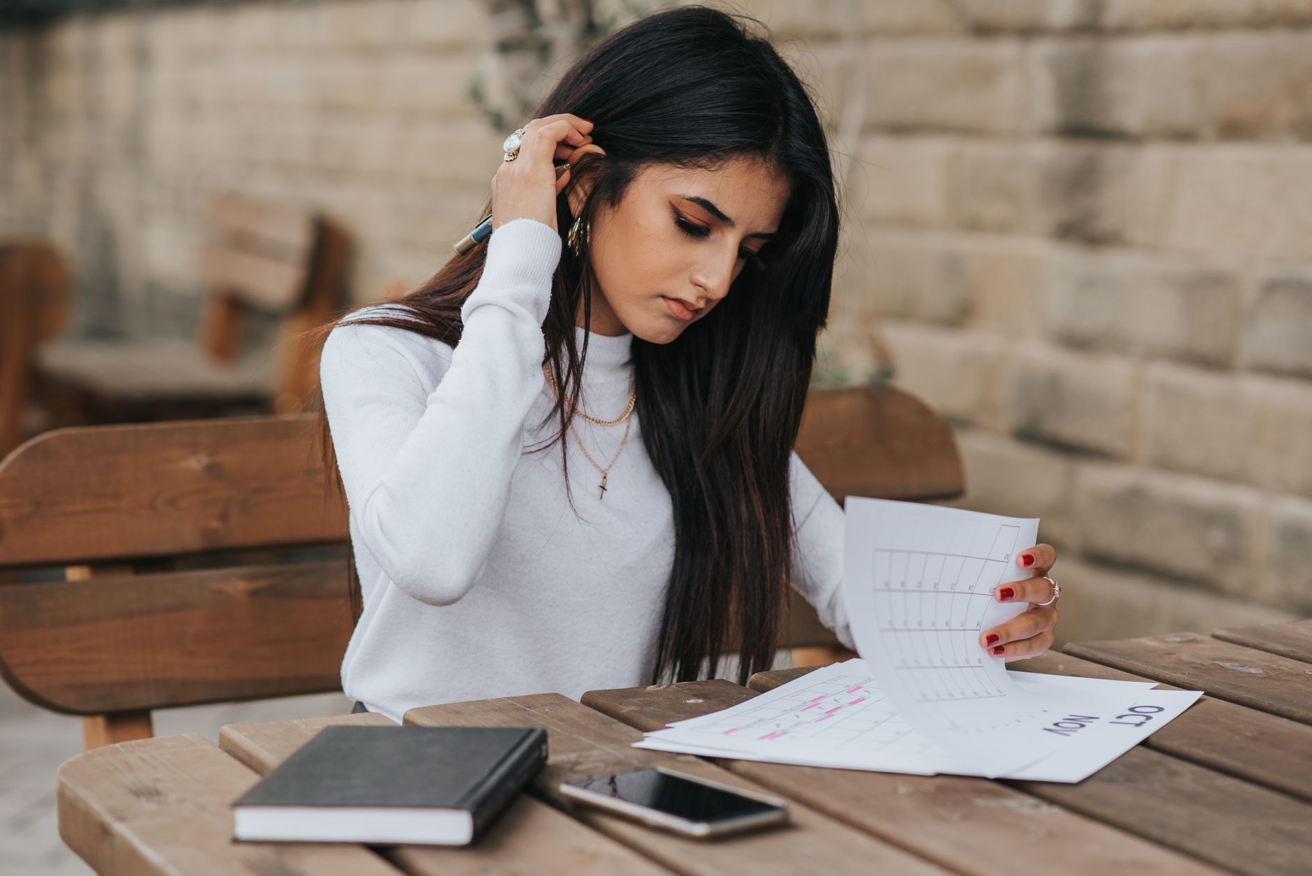A person reading through handwritten notes at a desk