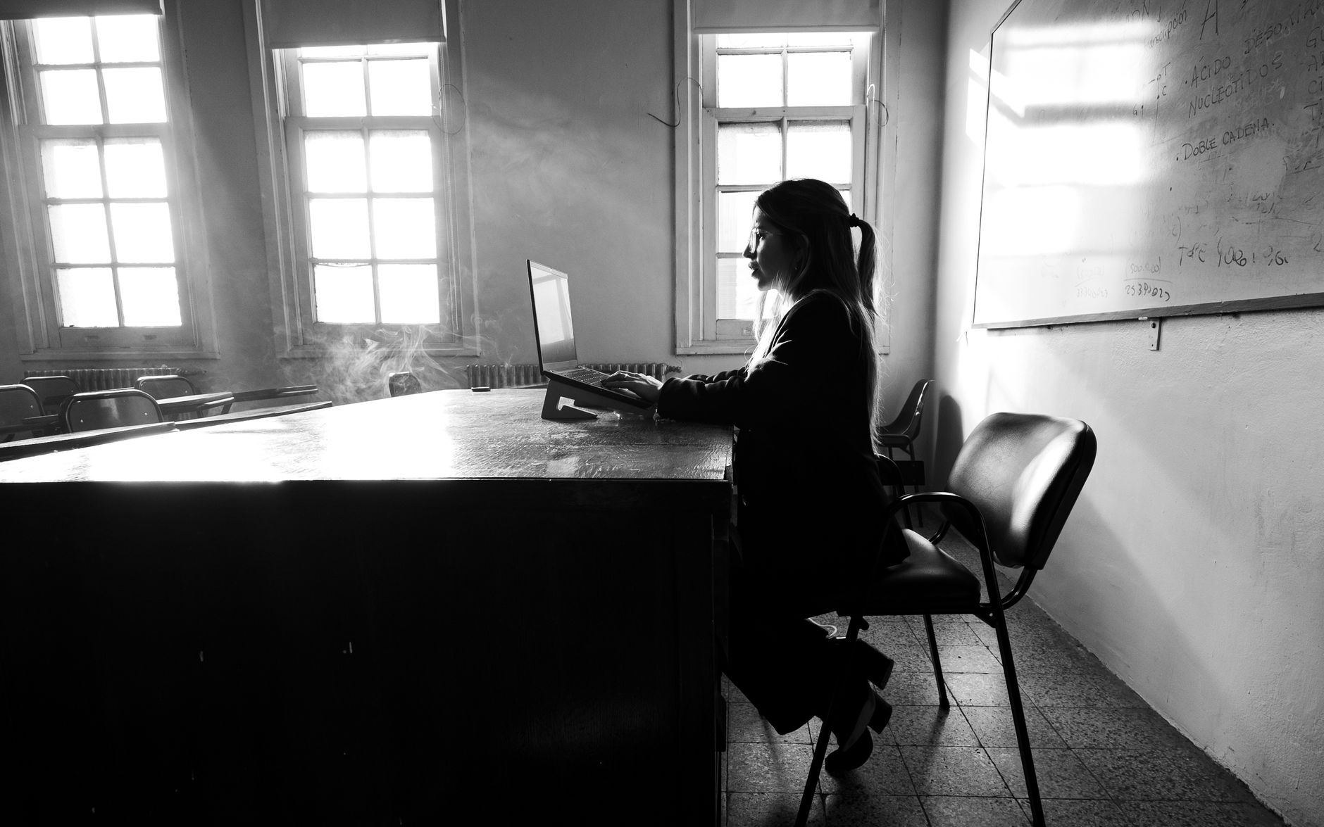 A university student working at a laptop at a desk