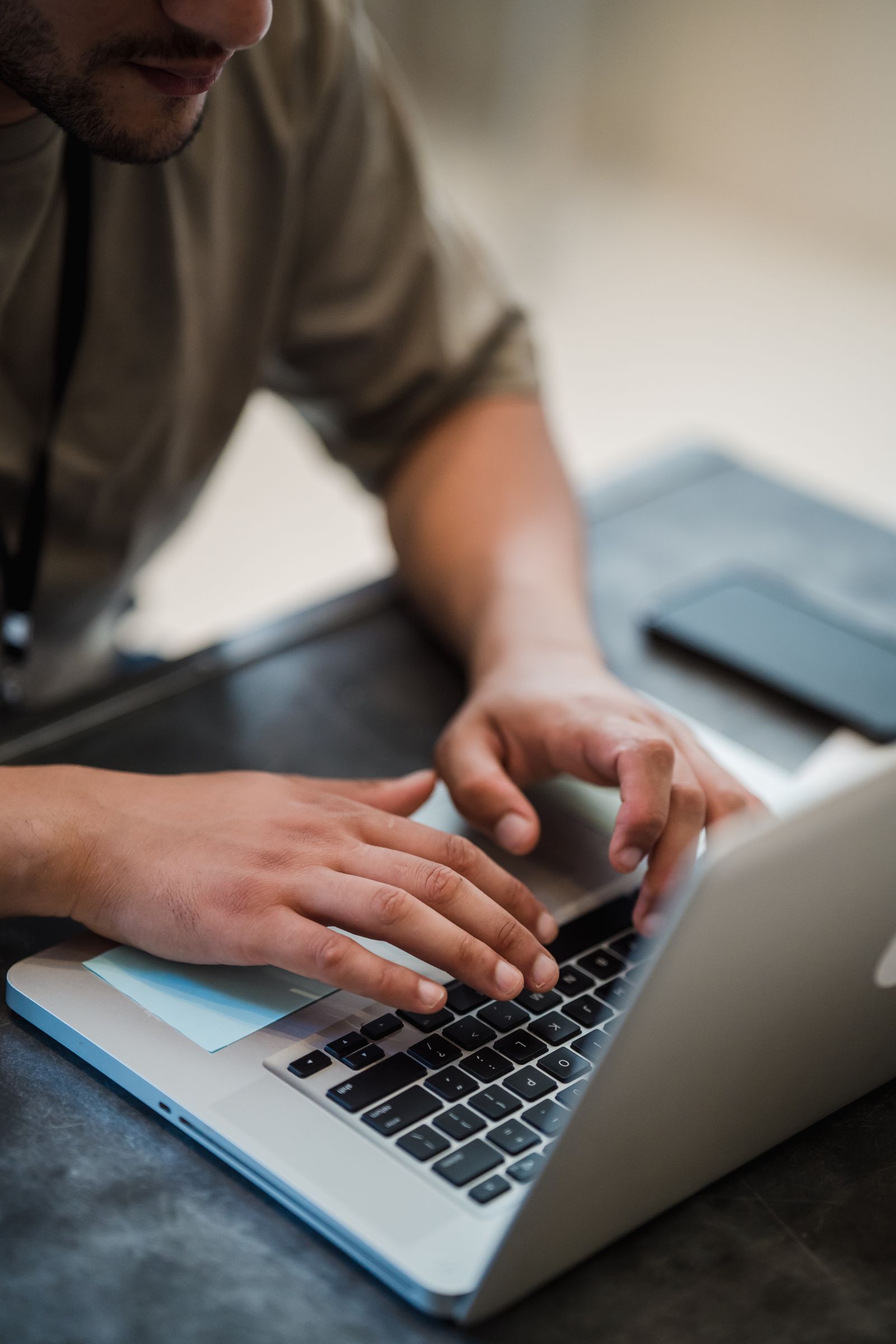 Close-up of hands typing on a laptop keyboard with a job listings page open on the screen, representing an automated job application tool at work