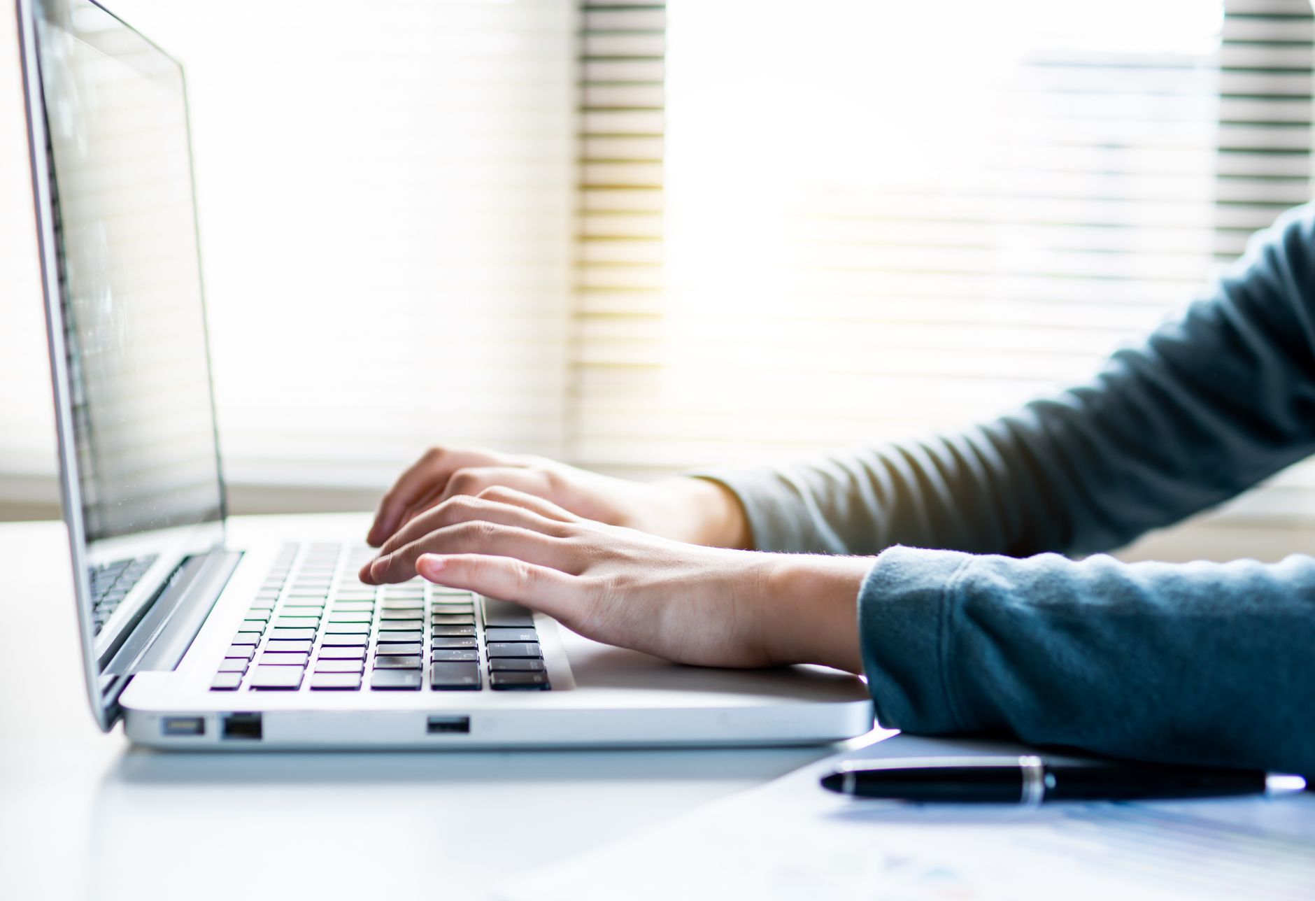 A person typing on a laptop while browsing job listings