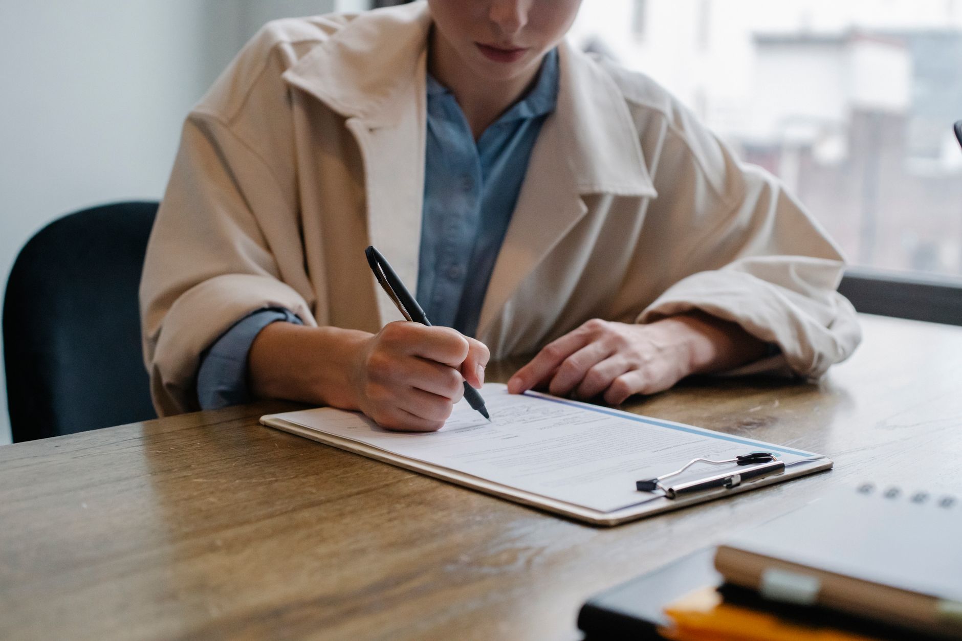A recruiter reviewing a resume on a clipboard during a hiring interview