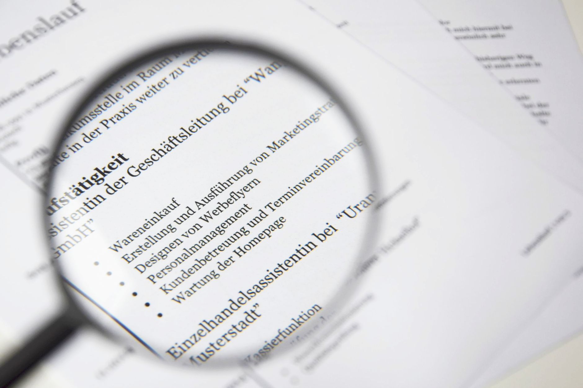 A magnifying glass resting beside a printed document