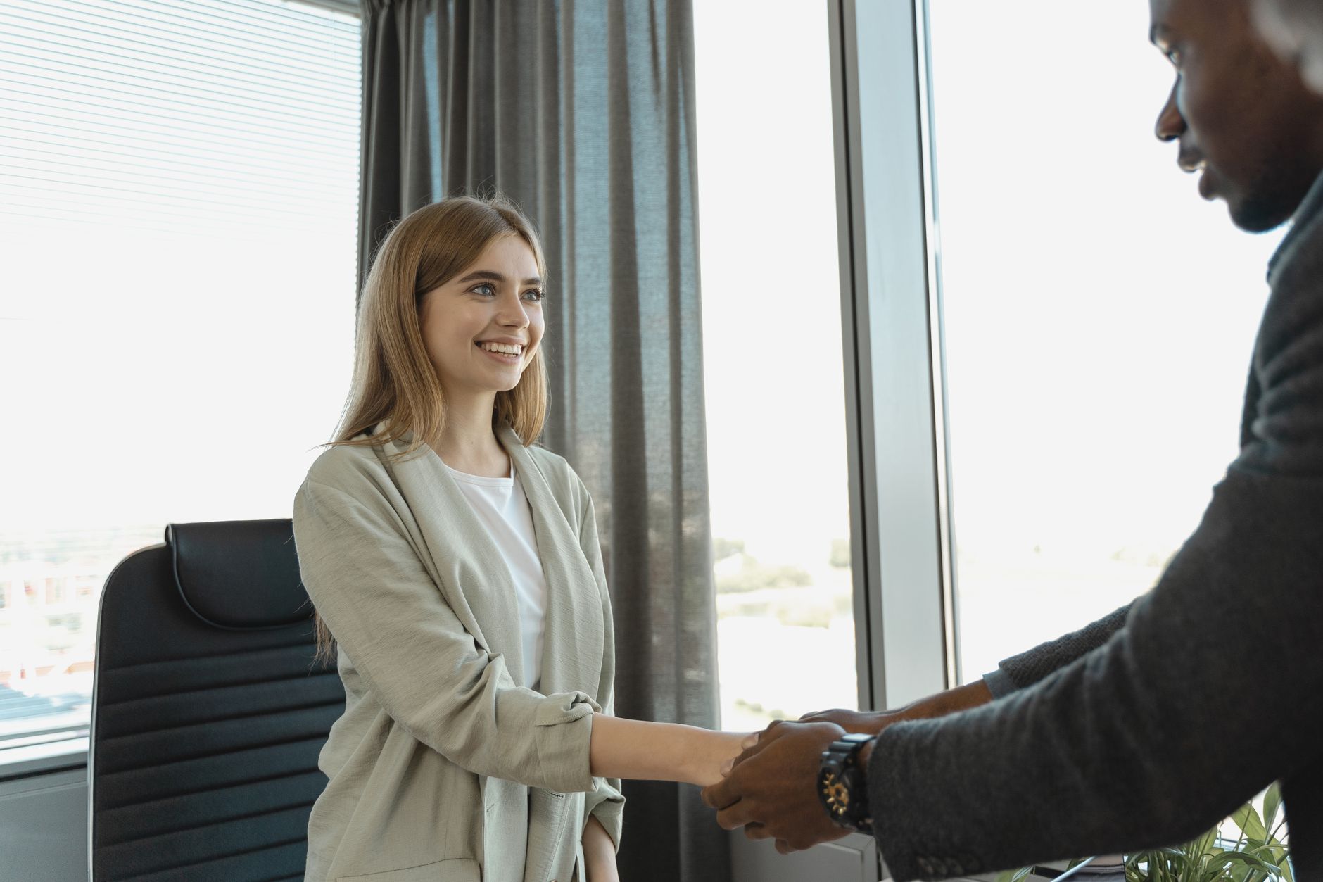 Two people shaking hands during a job interview